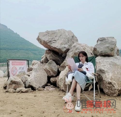 李智雅公开拍摄现场的幕后剪报 盘腿坐在石块前看剧本